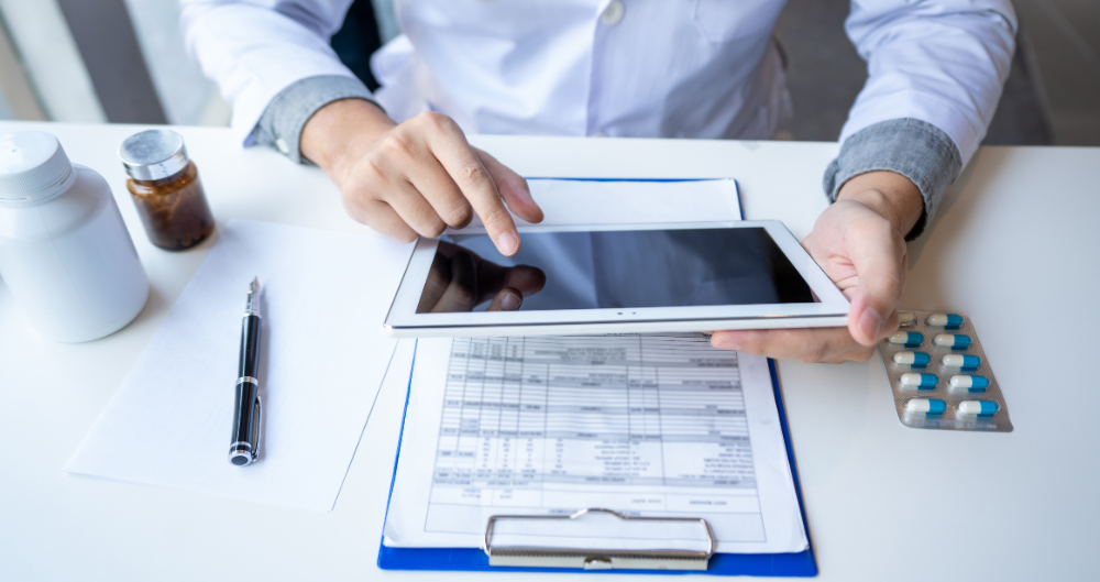 Healthcare Documentation Specialist professional reviewing patient records on a tablet and clipboard.