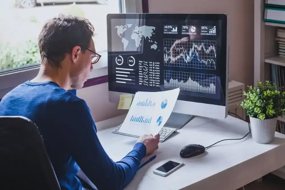 Man at computer with graphs