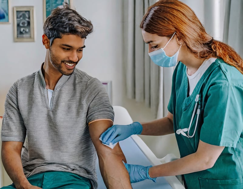 A woman preparing a man's arm for a blood draw